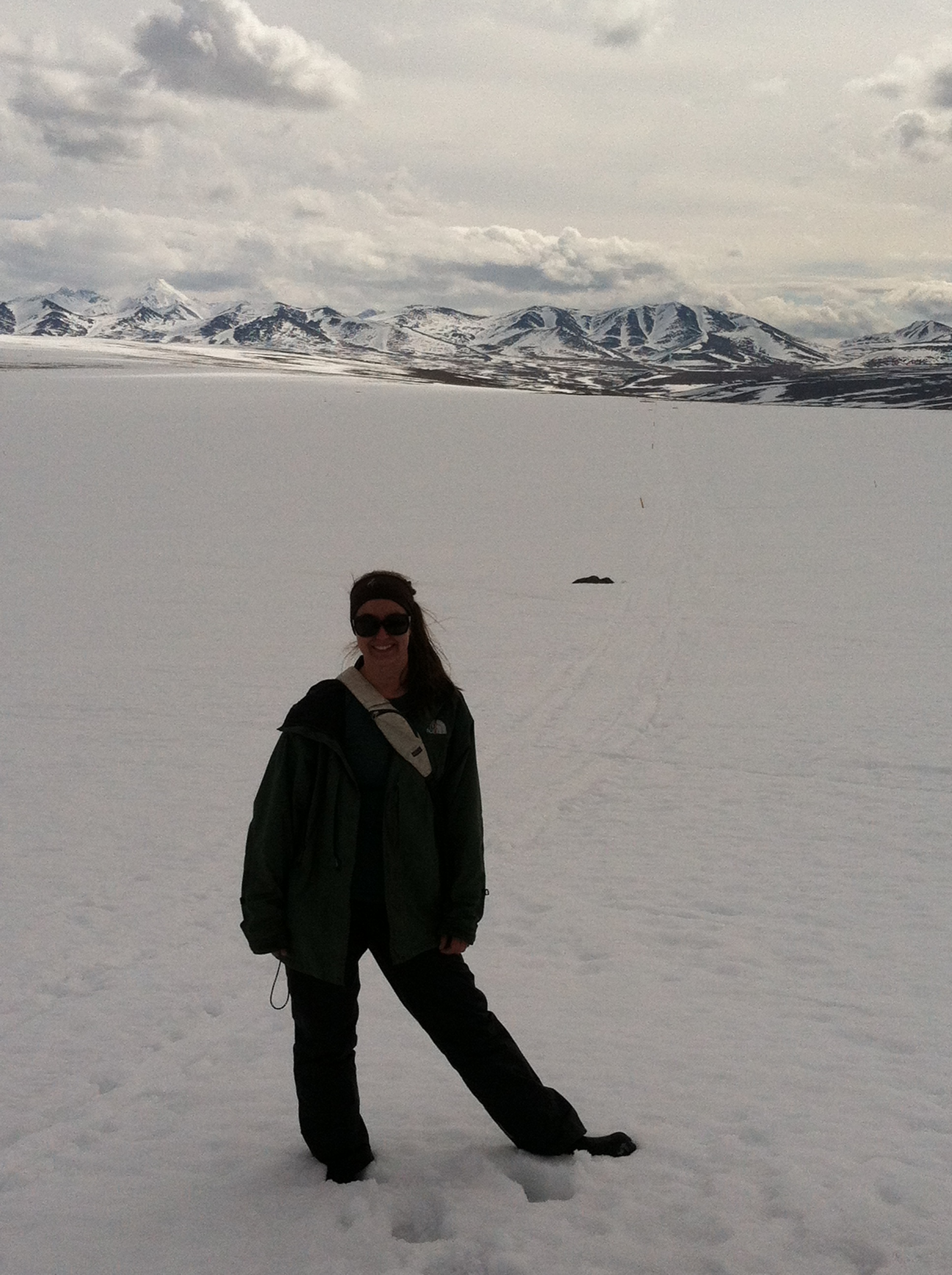 Megan Machmuller surveying snow-covered field sites, Alaska